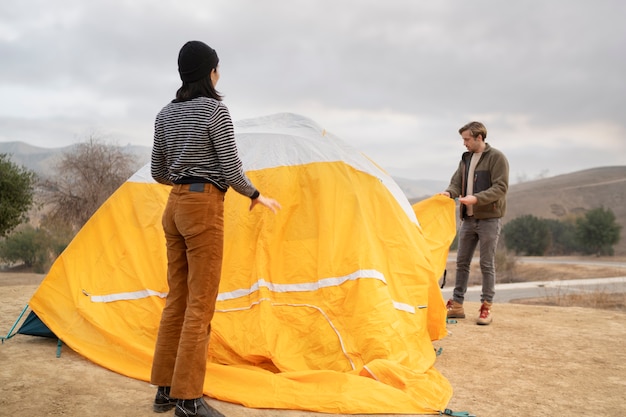 Personas preparando su carpa para acampar en invierno.