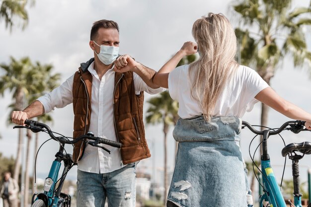 Personas que andan en bicicleta con una máscara médica.