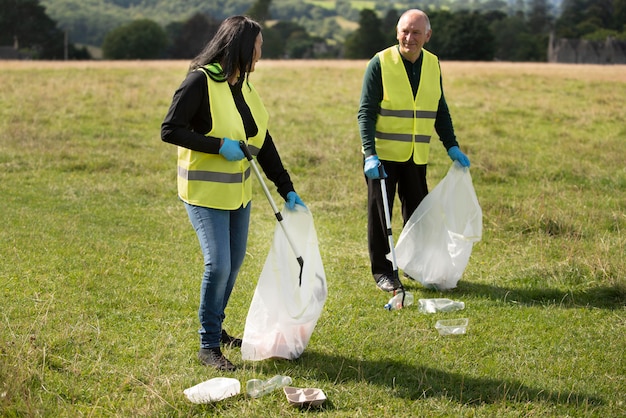 Foto gratuita personas que hacen servicio comunitario recolectando basura.