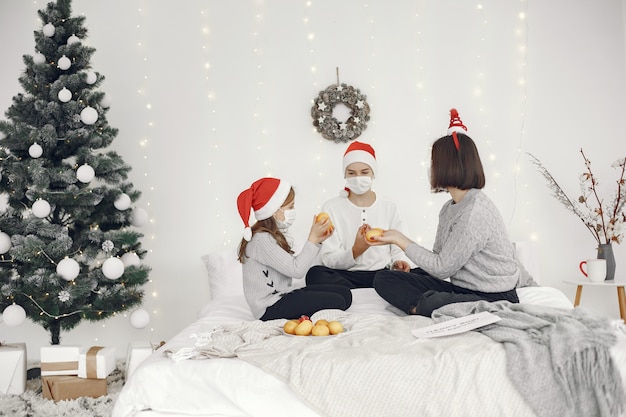Personas que se preparan para Navidad. Dos madres jugando con sus hijos. Hora del coronavirus. Aislamiento.