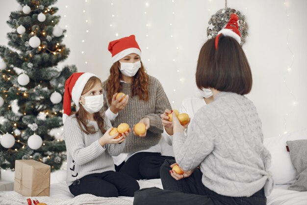 Personas que se preparan para Navidad. Dos madres jugando con sus hijos. Hora del coronavirus. Aislamiento.