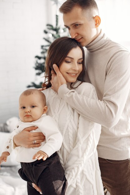 Personas que se preparan para la Navidad. Gente junto al árbol de Navidad. La familia está descansando en una sala festiva.