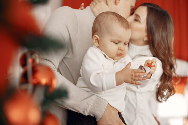 Personas que se preparan para la Navidad. Gente junto al árbol de Navidad. La familia está descansando en una sala festiva.