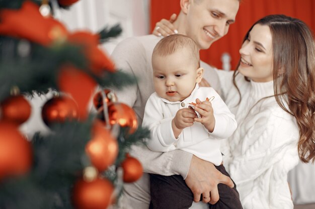 Personas que se preparan para la Navidad. Gente junto al árbol de Navidad. La familia está descansando en una sala festiva.