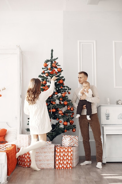 Personas que se preparan para la Navidad. Gente junto al árbol de Navidad. La familia está descansando en una sala festiva.