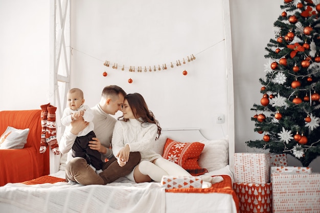 Personas que se preparan para la Navidad. Gente sentada en una cama. La familia está descansando en una sala festiva.