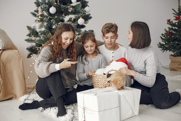 Personas que se preparan para Navidad. Gente sentada junto al árbol de Navidad.