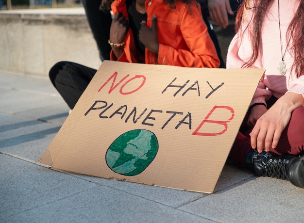 Personas que protestaban por el medio ambiente con cartel.