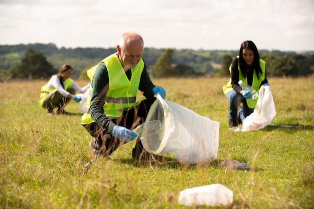 Personas que realizan servicio comunitario recogiendo basura al aire libre.