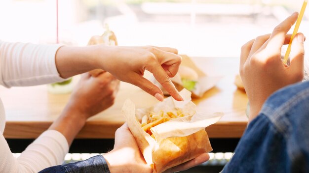 Personas que tienen comida rápida con papas fritas