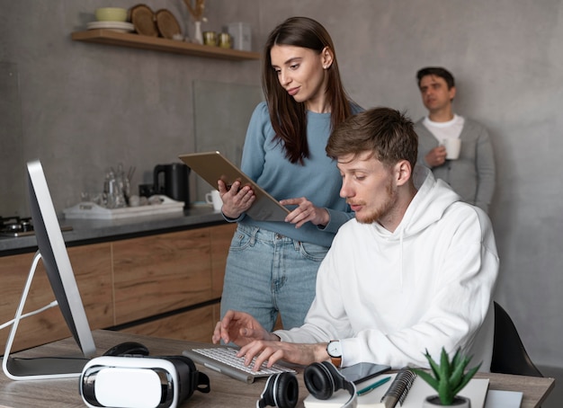 Foto gratuita personas que trabajan en el campo de los medios de comunicación con tableta y computadora.