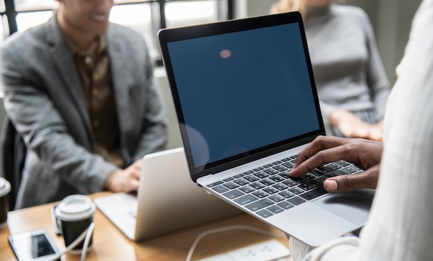 Personas que trabajan en una computadora portátil en una reunión