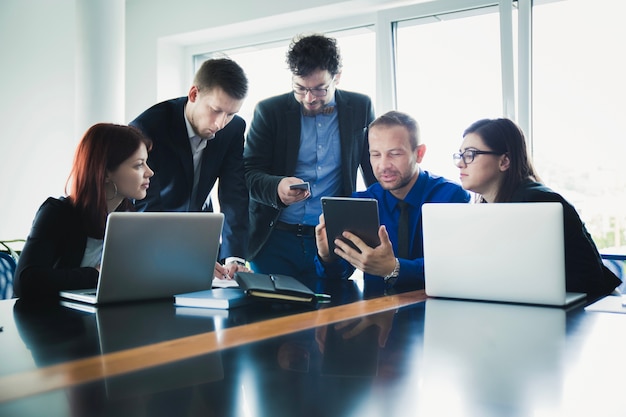 Personas que trabajan con dispositivos en la oficina