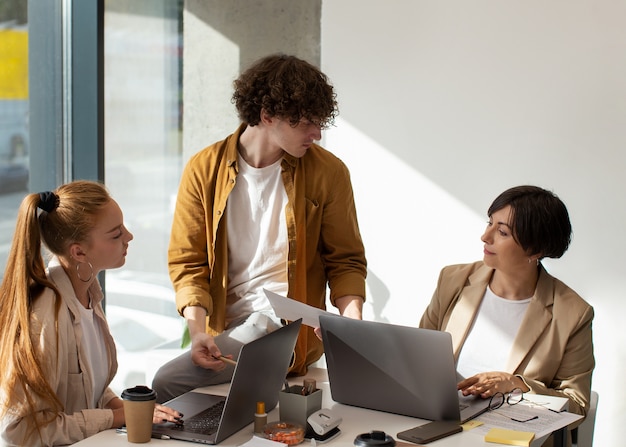 Foto gratuita personas que trabajan en la oficina plano medio