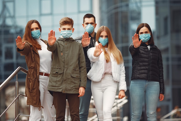 Las personas que usan máscaras protectoras muestran señales de alto con las manos