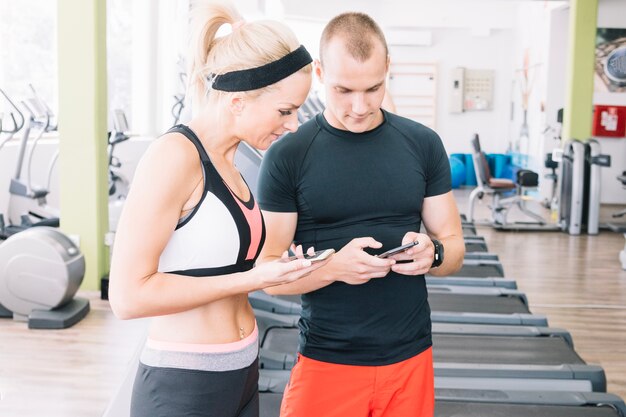 Personas que usan teléfonos en el gimnasio