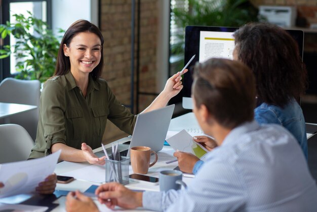 Personas que utilizan dispositivos digitales durante una reunión