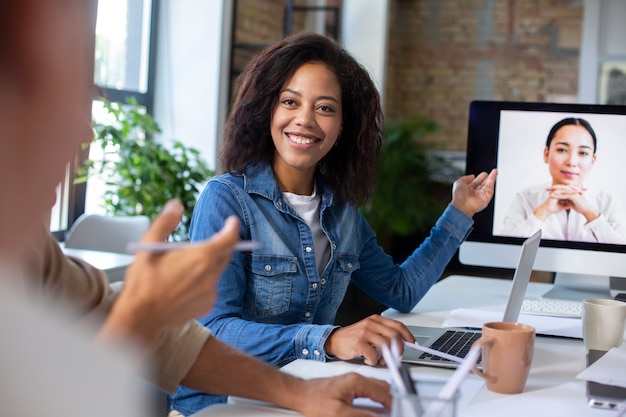 Foto gratuita personas que utilizan dispositivos digitales durante una reunión