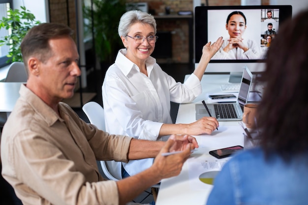 Personas que utilizan dispositivos digitales durante una reunión