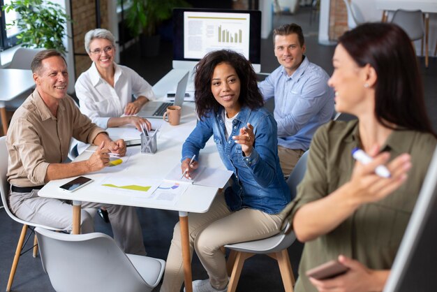 Personas que utilizan dispositivos digitales durante una reunión