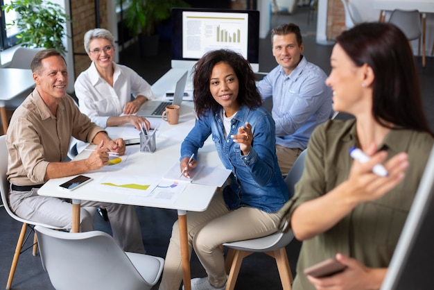 Personas que utilizan dispositivos digitales durante una reunión