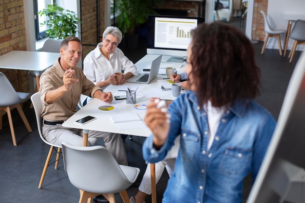 Personas que utilizan dispositivos digitales durante una reunión