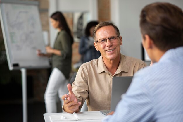 Personas que utilizan dispositivos digitales durante una reunión