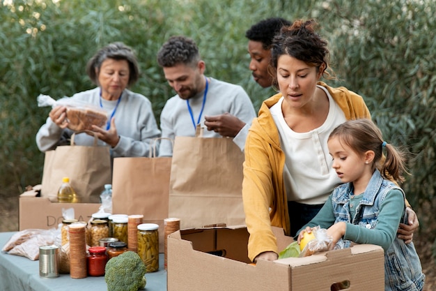 Personas recolectando donaciones de alimentos plano medio.