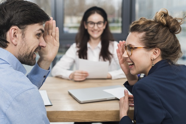 Personas de recursos humanos que hablan de una mujer que asiste a una entrevista de trabajo