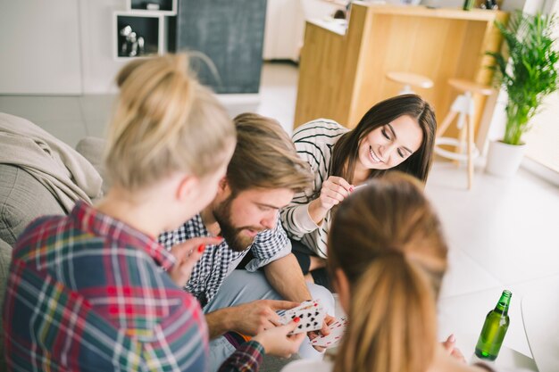 Personas relajantes jugando a las cartas en casa