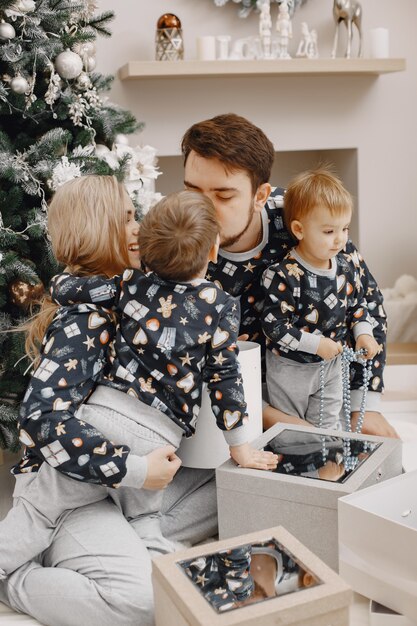 Personas reparando para Navidad. Gente jugando con niño. La familia está descansando en una sala festiva.