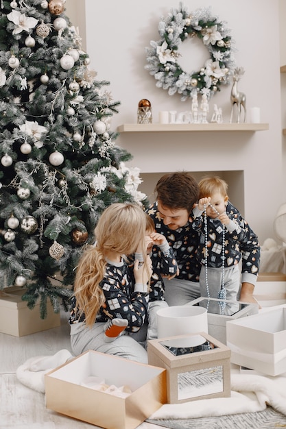 Personas reparando para Navidad. Gente jugando con niño. La familia está descansando en una sala festiva.