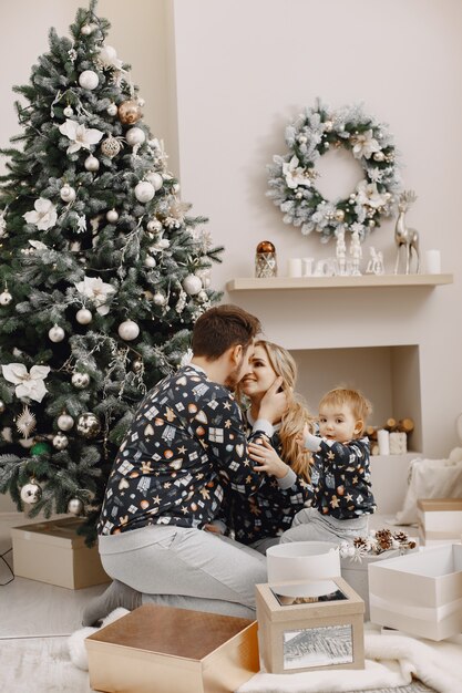 Personas reparando para Navidad. Gente jugando con niño. La familia está descansando en una sala festiva.