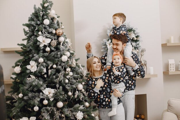 Personas reparando para Navidad. Gente jugando con niño. La familia está descansando en una sala festiva.