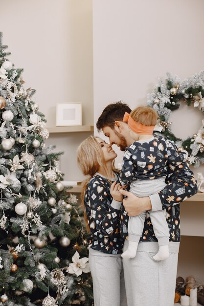 Personas reparando para Navidad. Gente jugando con niño. La familia está descansando en una sala festiva.