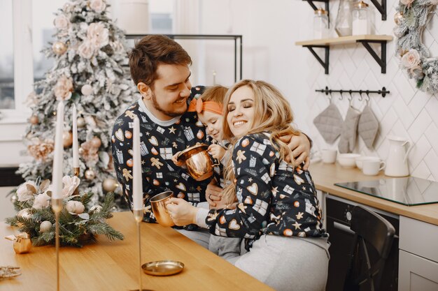 Personas reparando para Navidad. Gente jugando con su hija. La familia está descansando en una cocina festiva.