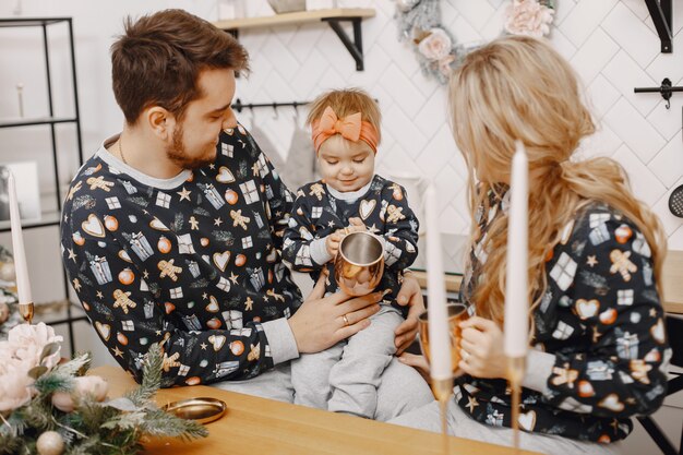 Personas reparando para Navidad. Gente jugando con su hija. La familia está descansando en una cocina festiva.