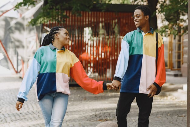 Personas con ropa de identificación. Pareja africana en la ciudad de otoño.