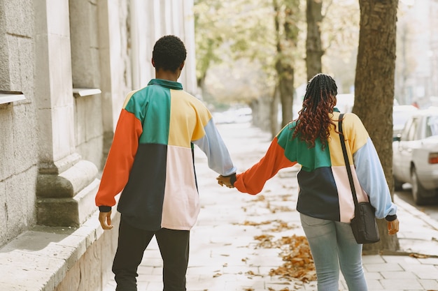 Personas con ropa de identificación. Pareja africana en la ciudad de otoño.