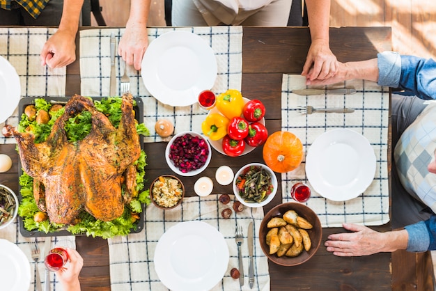 Personas sentadas a la mesa con comida diferente.