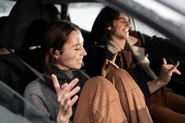 Personas sonrientes de plano medio que viajan en coche