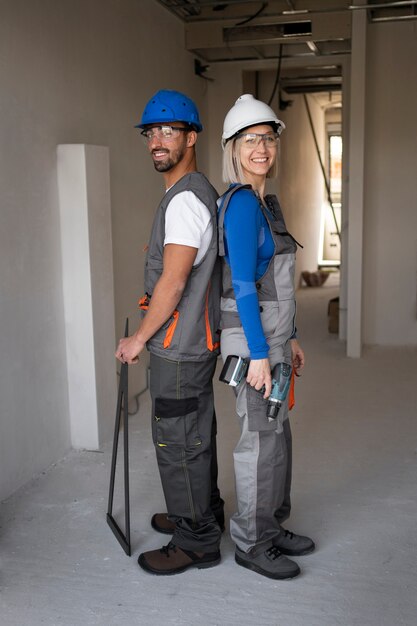 Personas sonrientes de tiro completo con cascos de seguridad