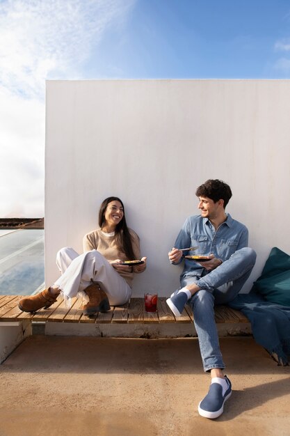 Personas sonrientes de tiro completo con comida deliciosa