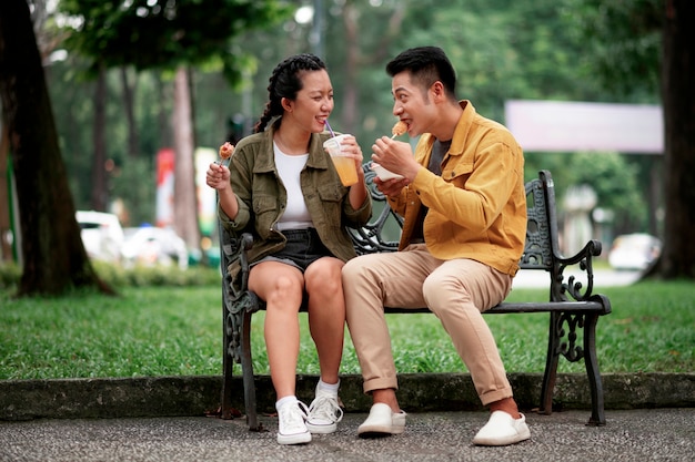 Foto gratuita personas sonrientes de tiro completo con comida