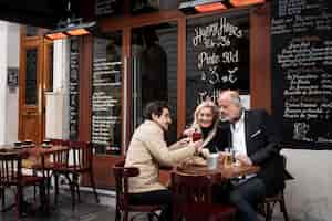 Foto gratuita personas sonrientes de tiro medio con bebidas en bistro