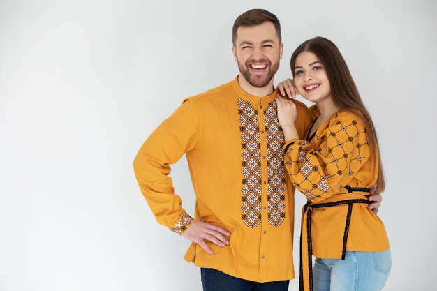 Foto gratuita personas sonrientes de tiro medio con camisa bordada