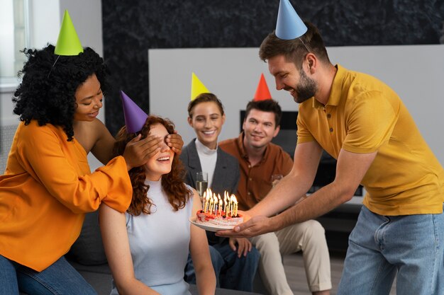 Personas sonrientes de tiro medio celebrando con pastel