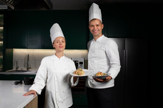 Personas sonrientes de tiro medio con comida deliciosa