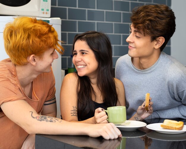 Personas sonrientes de tiro medio desayunando