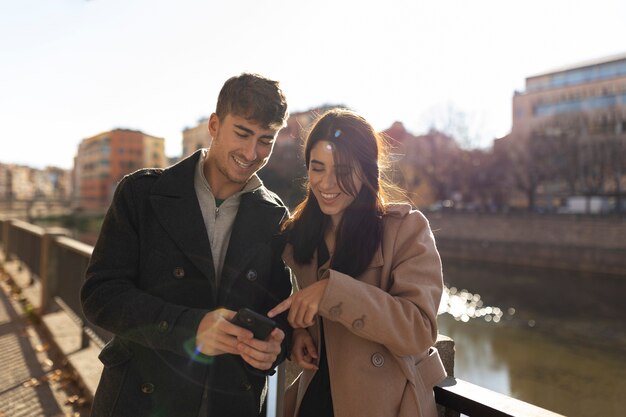 Personas sonrientes de tiro medio con teléfono